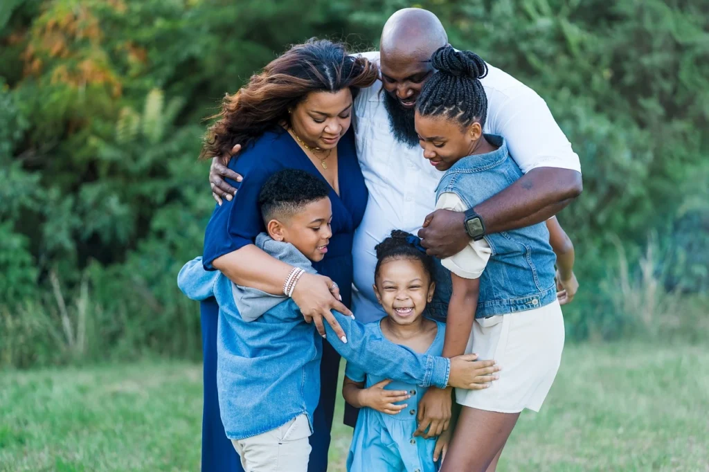 A loving family sitting together on a sofa, smiling and enjoying their time, symbolizing connection and togetherness.